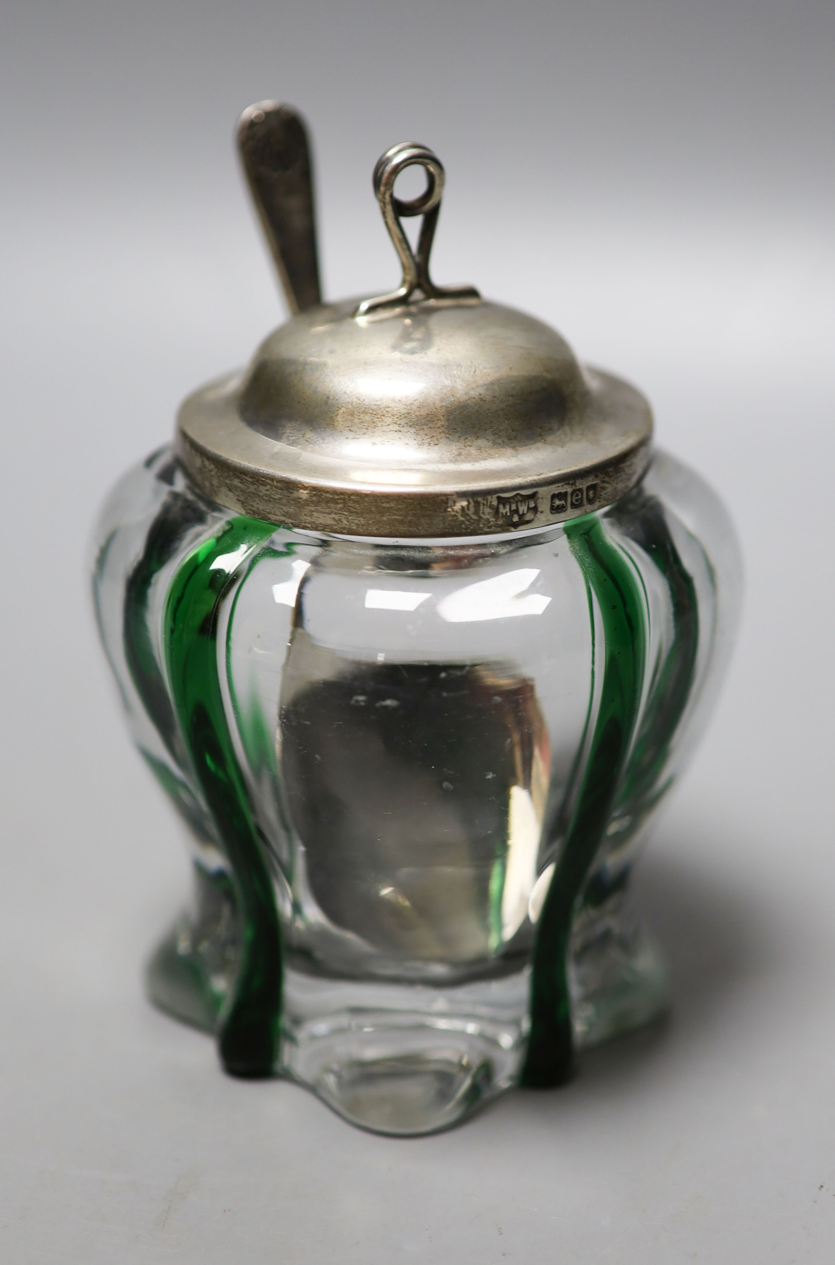 A late Victorian Art Nouveau silver mounted green and clear glass preserve pot, the glass probably James Powell & Sons, Mappin & Webb, London, 1900, 13.2cm, with later associated spoon